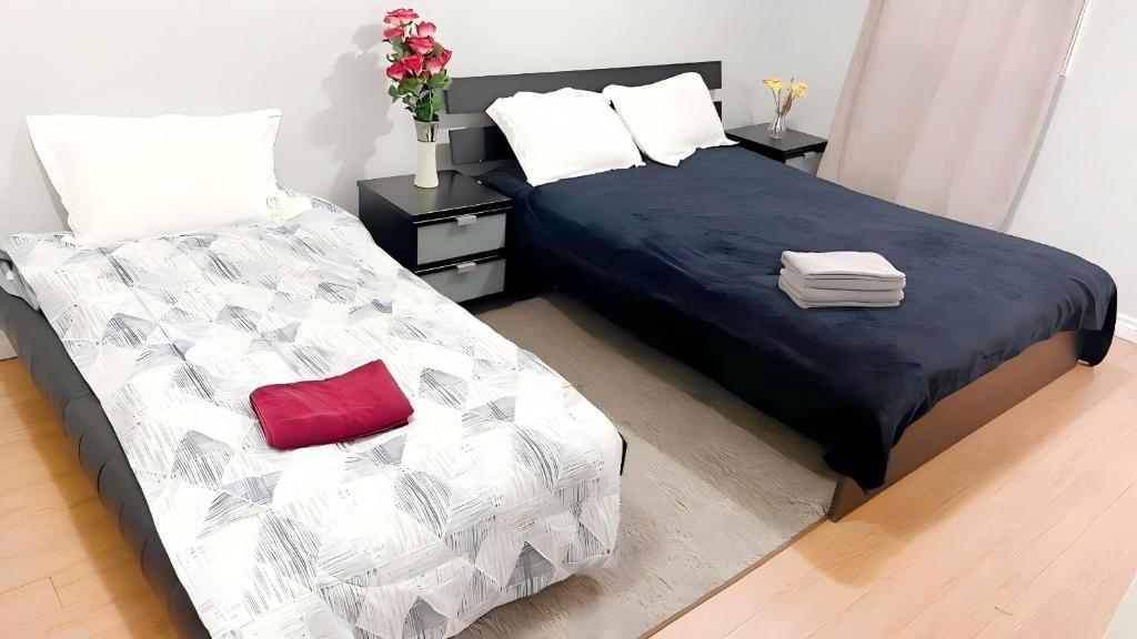 een slaapkamer met 2 bedden en een rood kussen bij warm heart toronto in Toronto