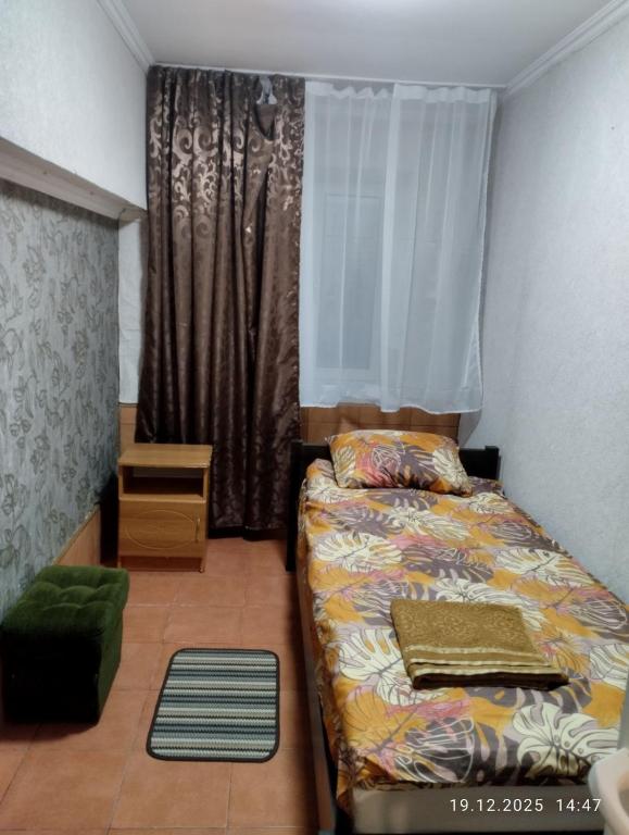 ein kleines Schlafzimmer mit einem Bett und einem Fenster in der Unterkunft Optimal 1 in Kiew