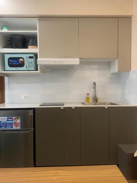 een keuken met een koelkast, een wastafel en een magnetron bij Centrio Tower New Condo unit 2 in Cagayan de Oro