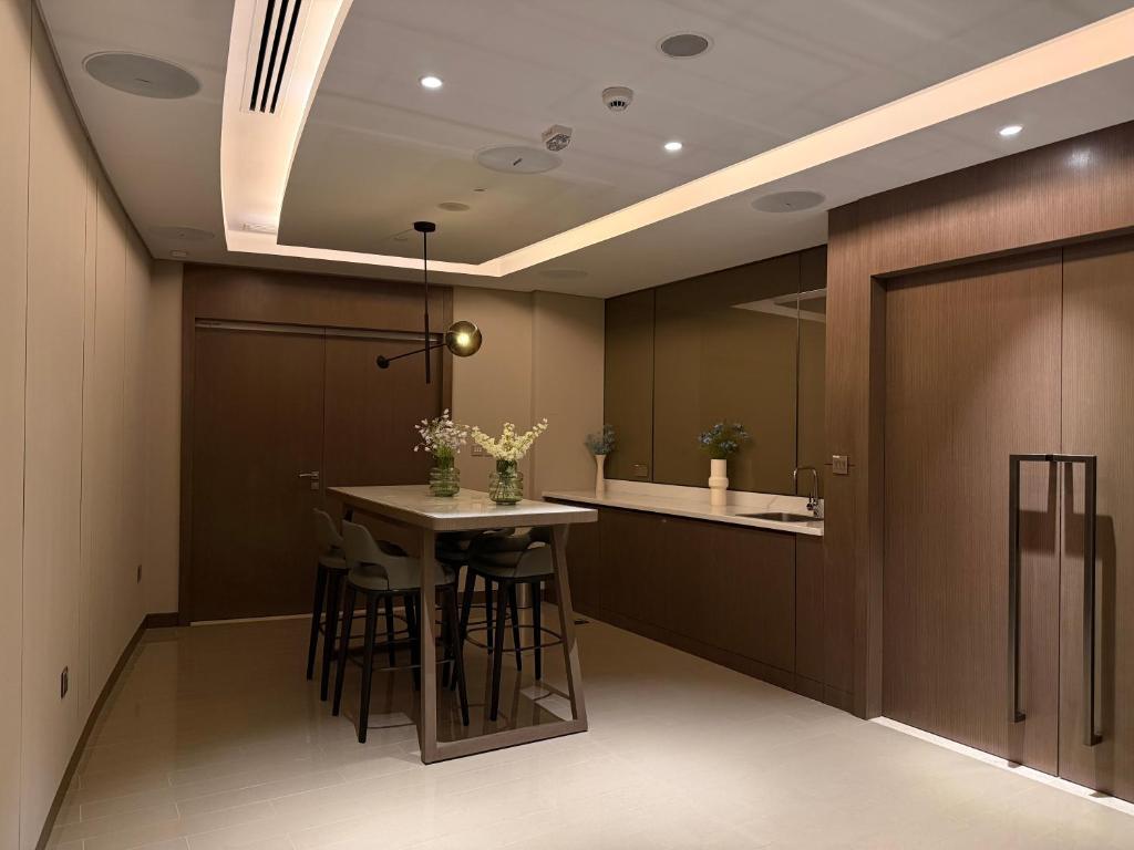 a kitchen with a table with stools in it at Opera Grand Luxury Apartment in Dubai