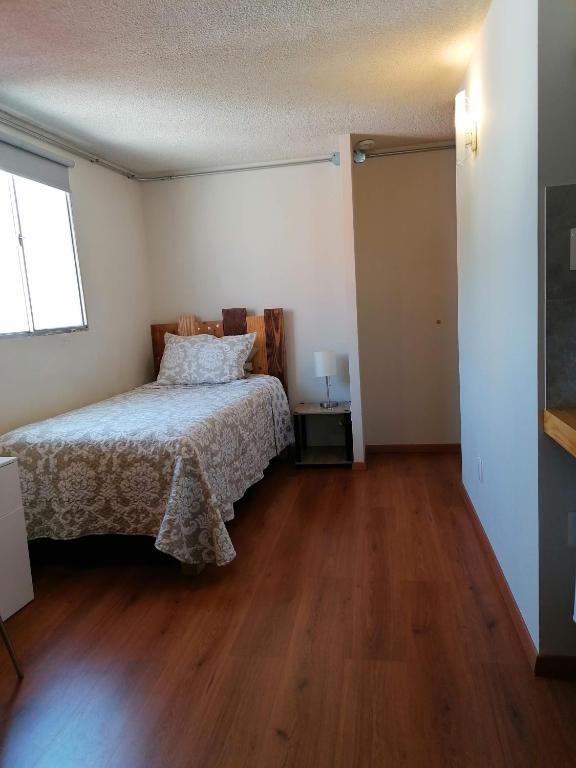 a bedroom with a bed and a wooden floor at Casagrande in San José de Malpaso
