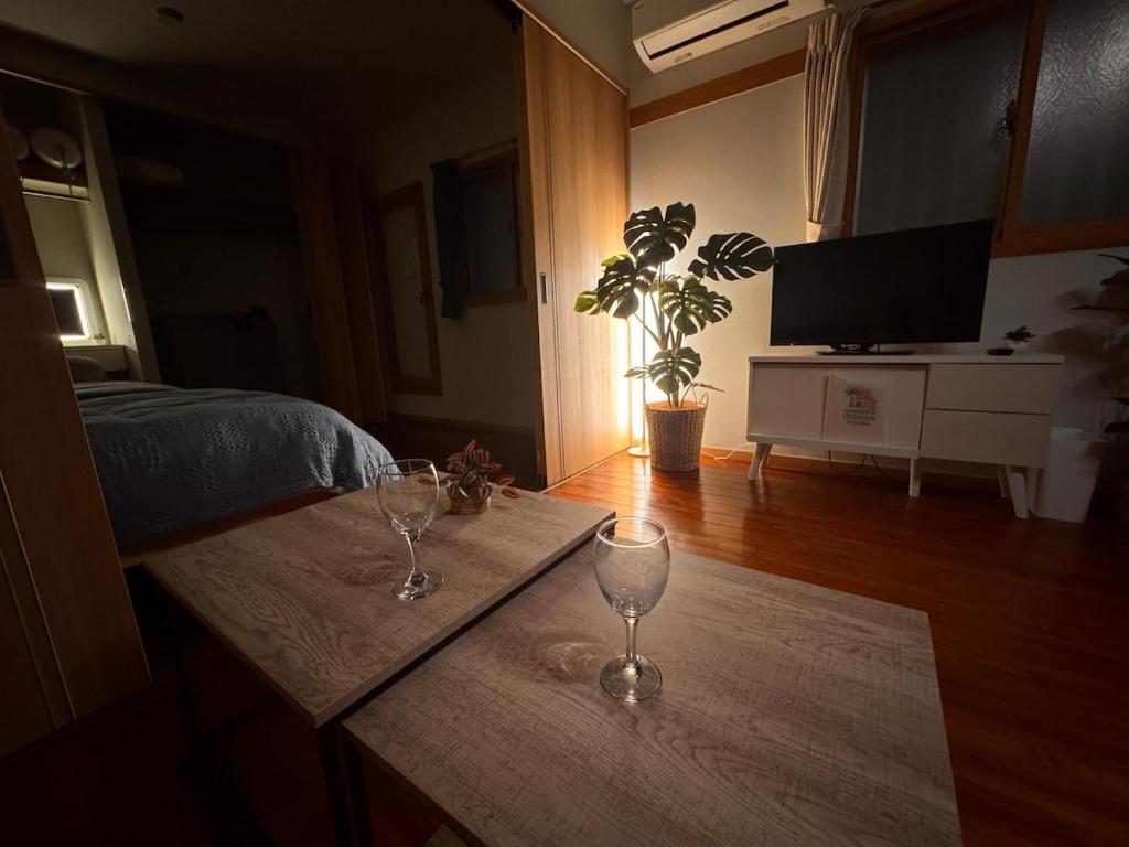 a room with a table with two wine glasses on it at HAMARs ITOMAN HOUSE - ReFaｼｬﾜｰﾍｯﾄﾞ&ﾄﾞﾗｲﾔｰ完備 - 南部観光の拠点 - 1日1組限定 in Itoman