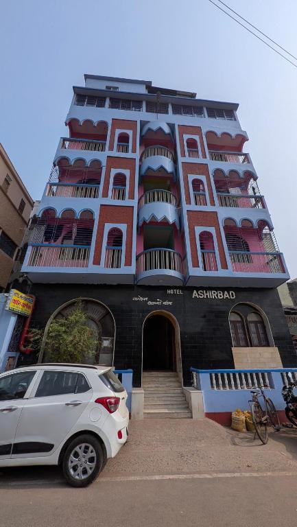 a white car parked in front of a building at Ashirbad hotel in Digha