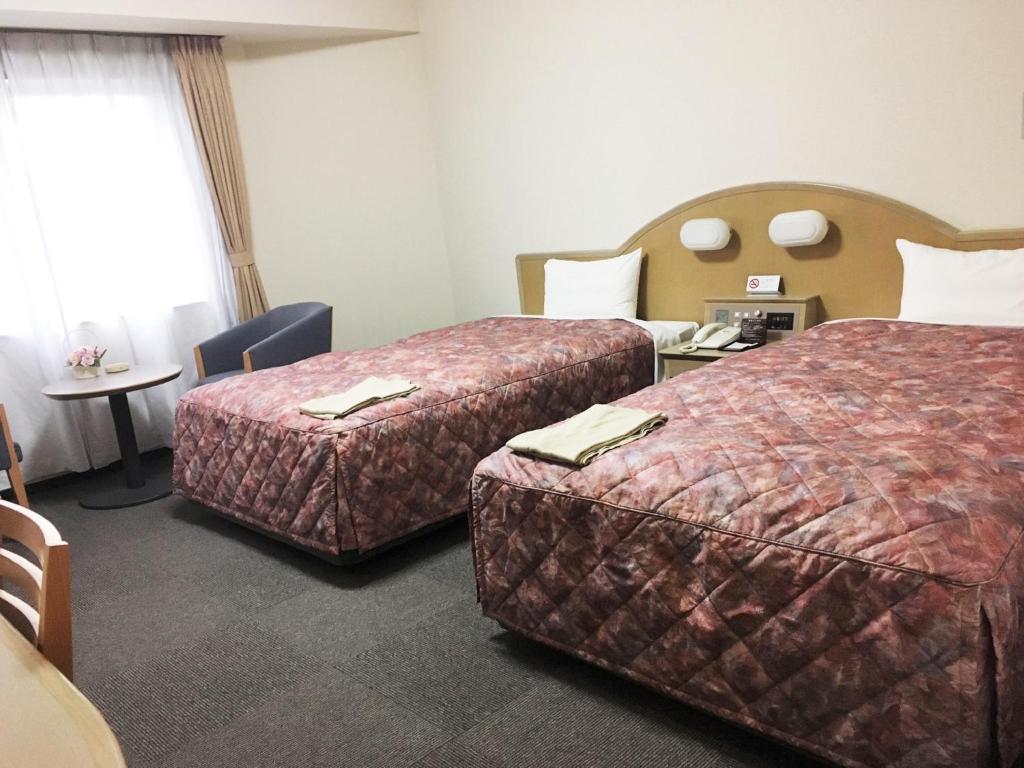 Postel nebo postele na pokoji v ubytování Oustat Kokusai Hotel Tajimi