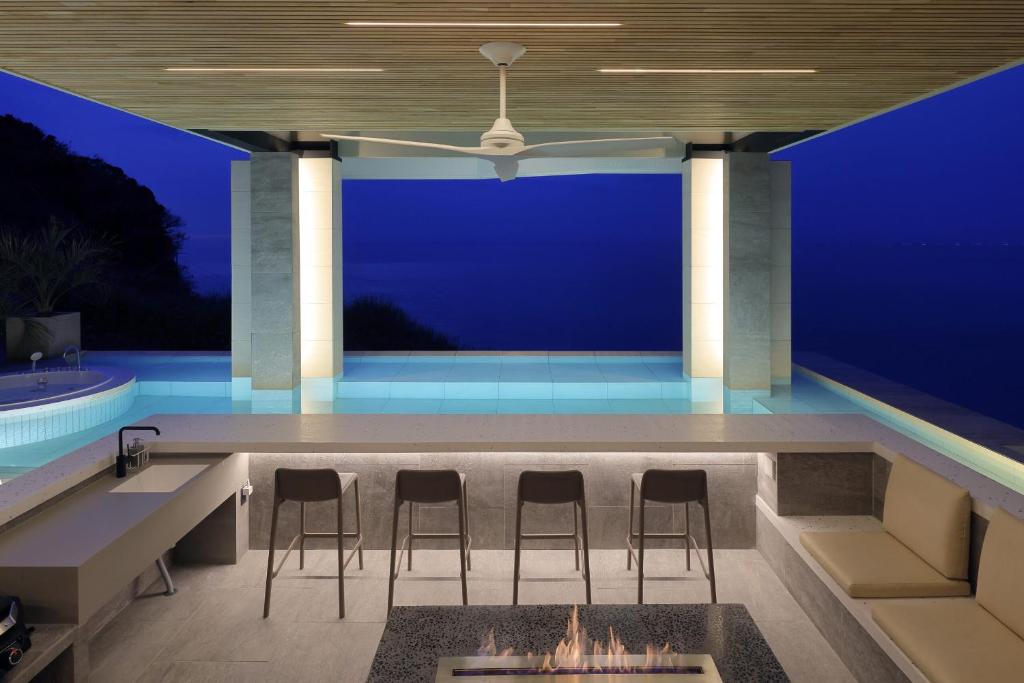 a patio with chairs and a fireplace in front of a blue wall at KONA RESORT AWAJI KAI in Awaji