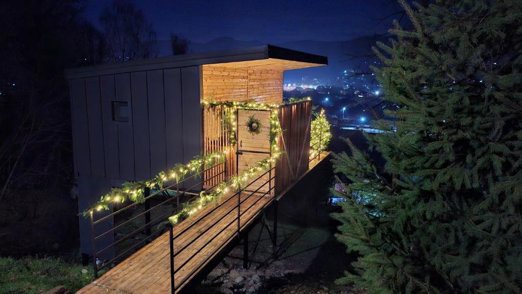a clock on a deck with christmas lights at Panoramic Box in Vişeu de Sus
