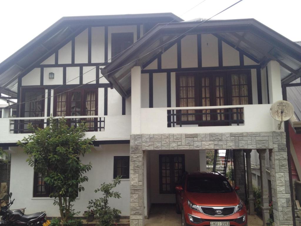 een huis met een auto ervoor geparkeerd bij Nuwara Eliya Homestay in Nuwara Eliya