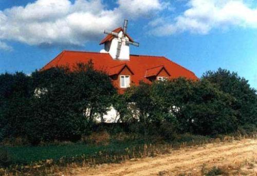 a house with a red roof with a windmill on it at Hotel garni Zur Mühle in Angermünde