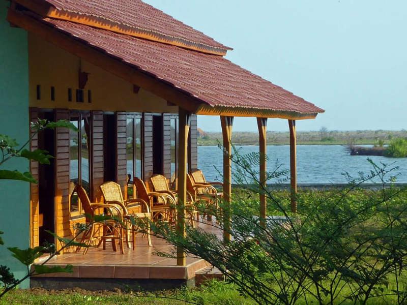 einen Pavillon mit Stühlen, einem Tisch und Wasser in der Unterkunft Java Lagoon in Pangandaran