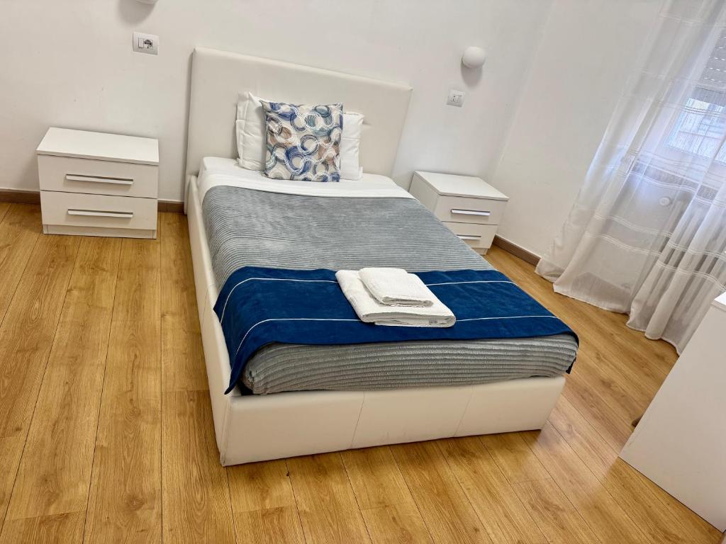 een slaapkamer met een wit bed met blauwe lakens bij Nuovo Confortini Rooms SUNDAY in Verona