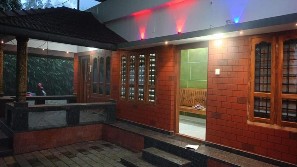 een kamer met een rode bakstenen muur en een raam bij Valley De Hills Farm Villa in Attappādi