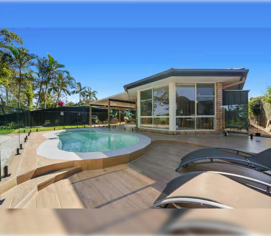 une maison avec piscine devant un immeuble dans l'établissement 4BR Coomera Views! Prime Gold Coast Near Beaches, à Gold Coast