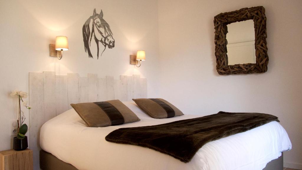 - une chambre avec un lit avec une tête de cheval sur le mur dans l'établissement Mas des Rièges & Spa, à Saintes-Maries-de-la-Mer