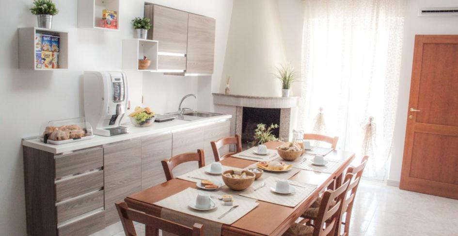 uma cozinha com mesa e cadeiras e uma cozinha com fogão em A Casa di Amici em Toritto