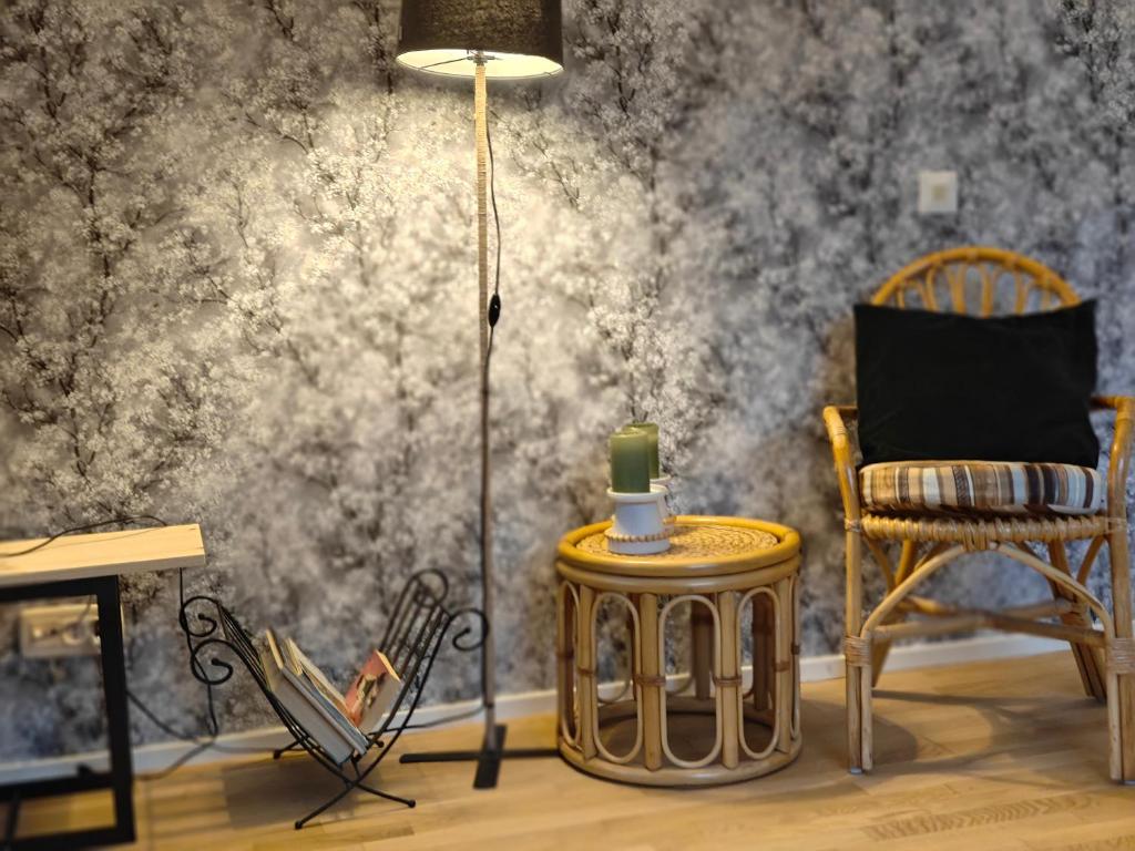 a room with a table and a lamp and chairs at Iso kolmio Torniossa in Tornio