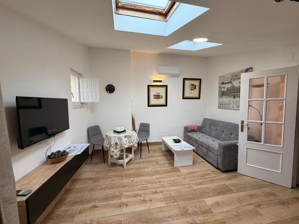 een woonkamer met een bank en een tv bij Casa De Los Aguilas in Avila