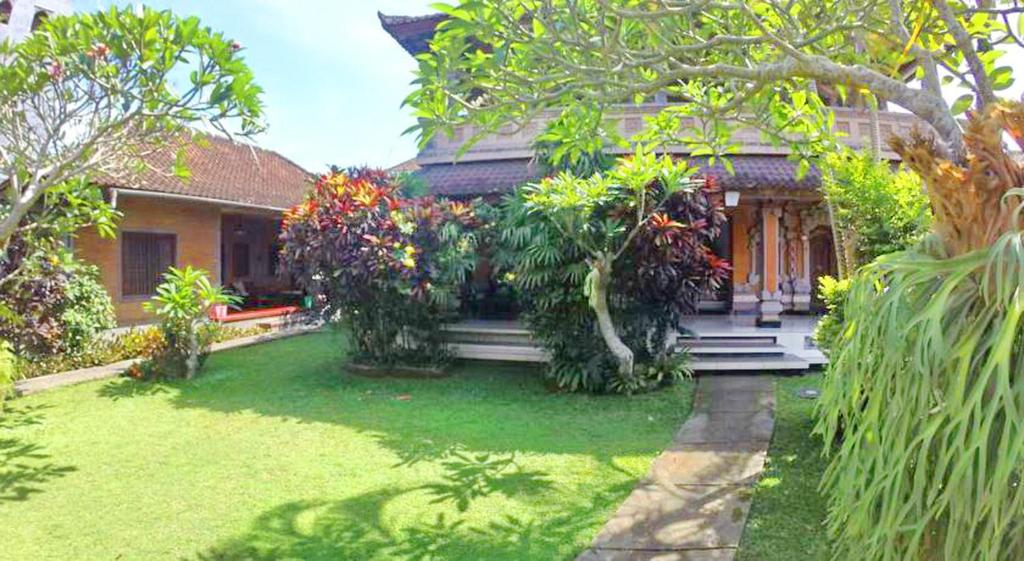 una casa con un jardín delante de ella en Sunarta House Homestay en Ubud