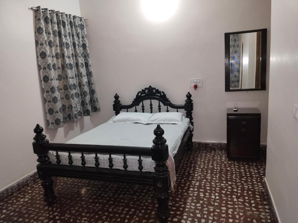 a bedroom with a bed with a black frame at Chaps le guest house in Patna