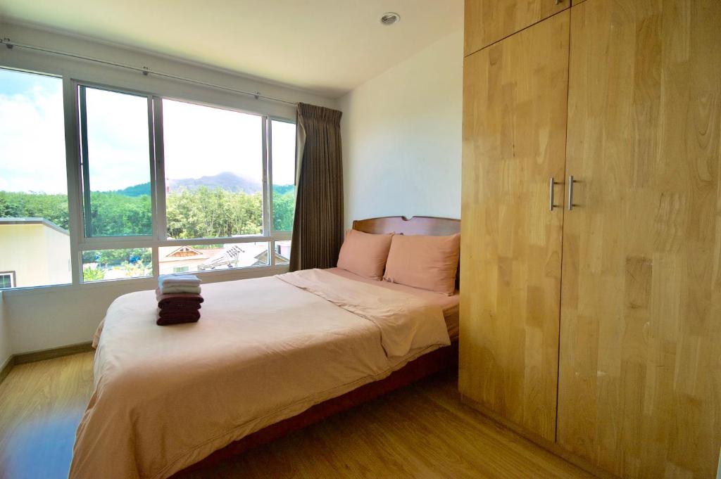 a bedroom with a bed and a large window at Risa Plus in Kathu