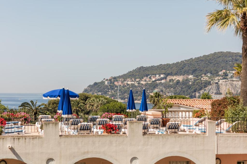 a view of a resort with chairs and umbrellas at Résidence Pierre & Vacances l'Ange Gardien in Villefranche-sur-Mer