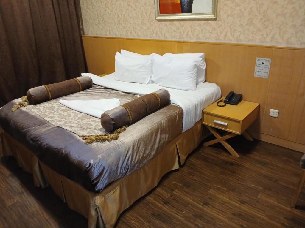 a large bed in a hotel room with a table at فندق رمال الخليج in Makkah