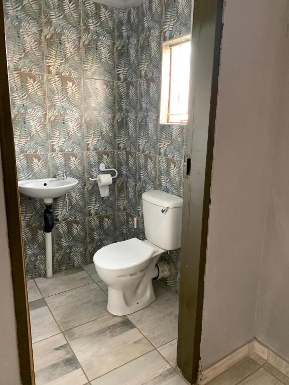 a bathroom with a toilet and a sink at ALMiRTY GUEST HOUSE in Grasmere