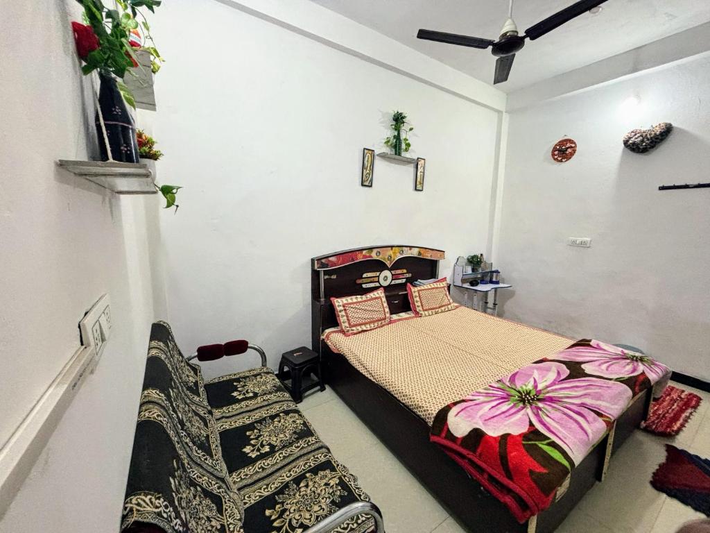a bedroom with a bed and a couch in it at Next Home Stay in Nalkhera
