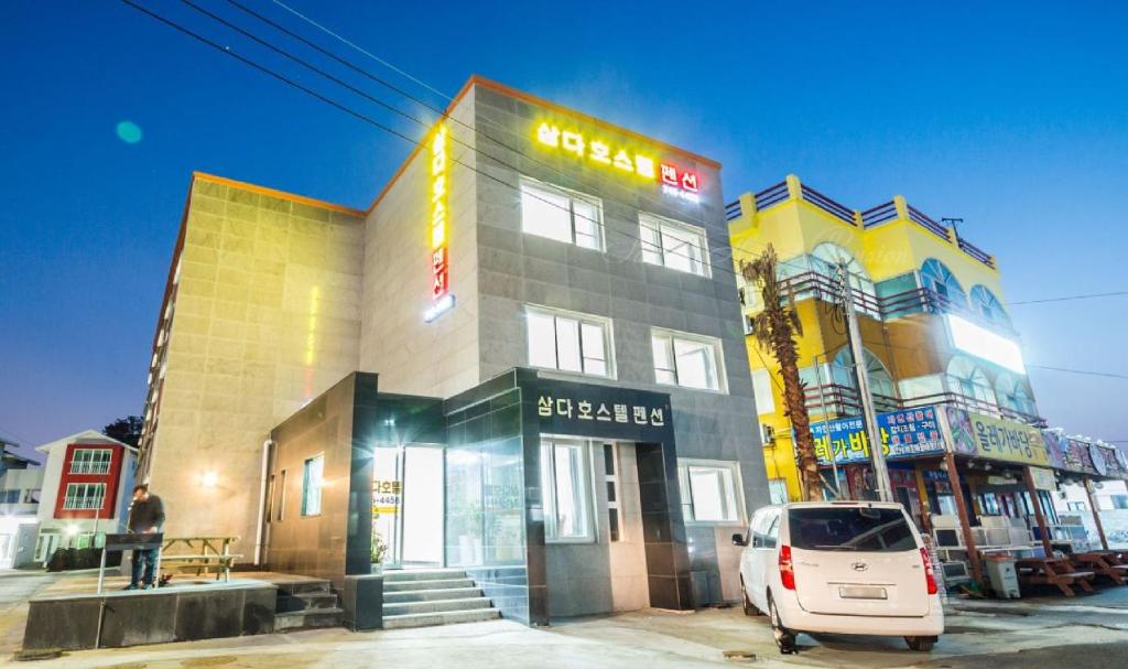 a white van parked in front of a building at Samda Hostel in Jeju