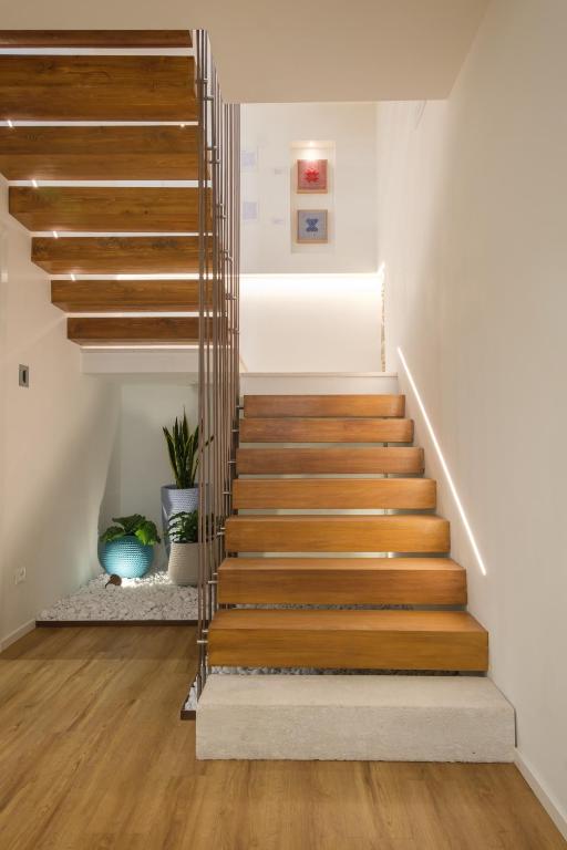 a staircase in a house with wood and metal railings at Emma's Downtown - Eco Design Rooms in Olbia