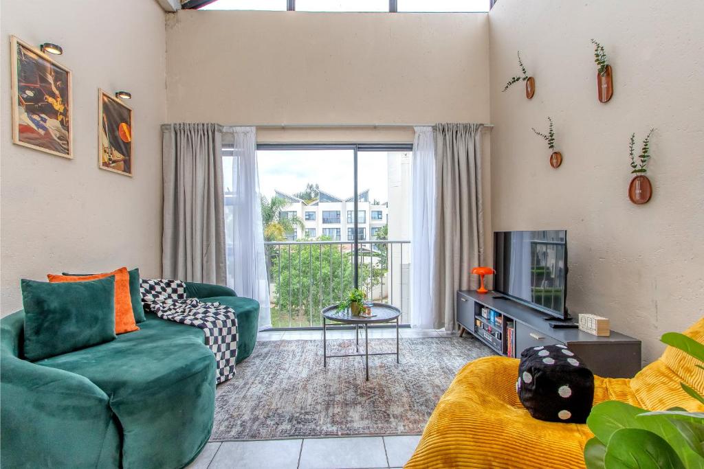 een woonkamer met een groene bank en een tv bij Retro Pop FREE Parking Fast Wifi Pool Large Workspace in Sandton