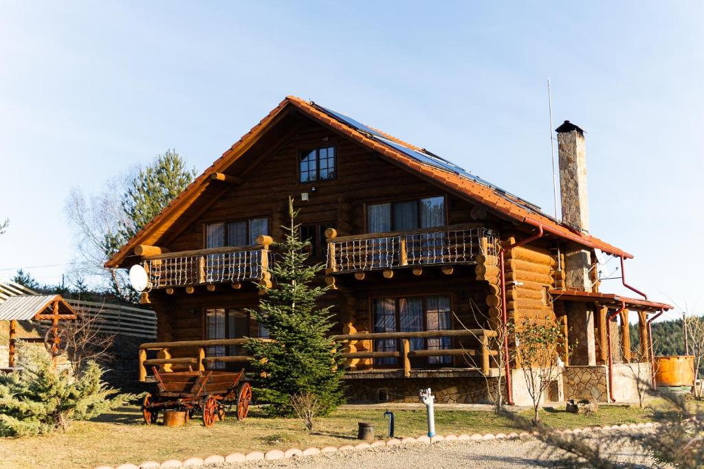 una baita di tronchi con veranda e balcone. di Mocearu Retreat 