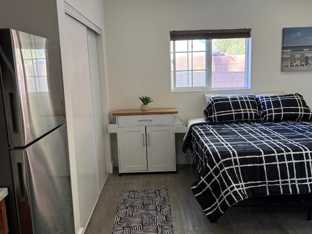 Kleines Zimmer mit 2 Betten und einem Kühlschrank. in der Unterkunft Hacienda Haven C in Las Vegas