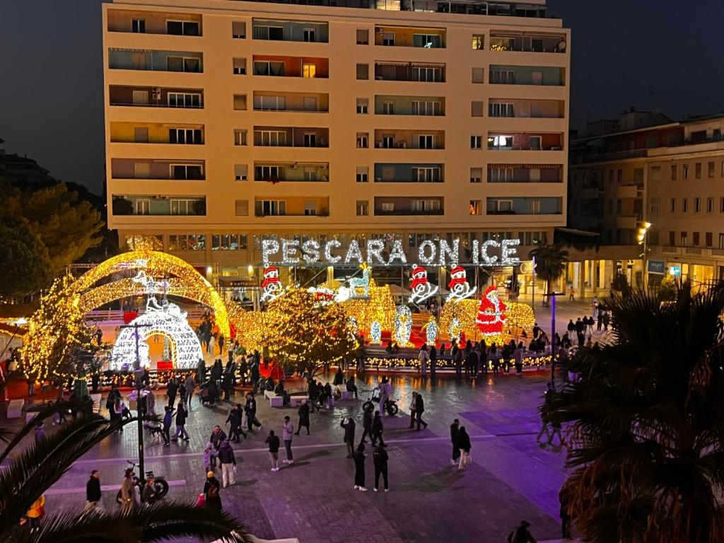 des gens qui se promènent sur une place en ville la nuit dans l'établissement MYHOME 75 Premium Luxury B&B, à Pescara