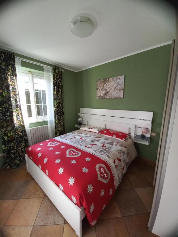 una camera da letto con un letto con una coperta rossa di Dimora degli Gnomi a Tirano