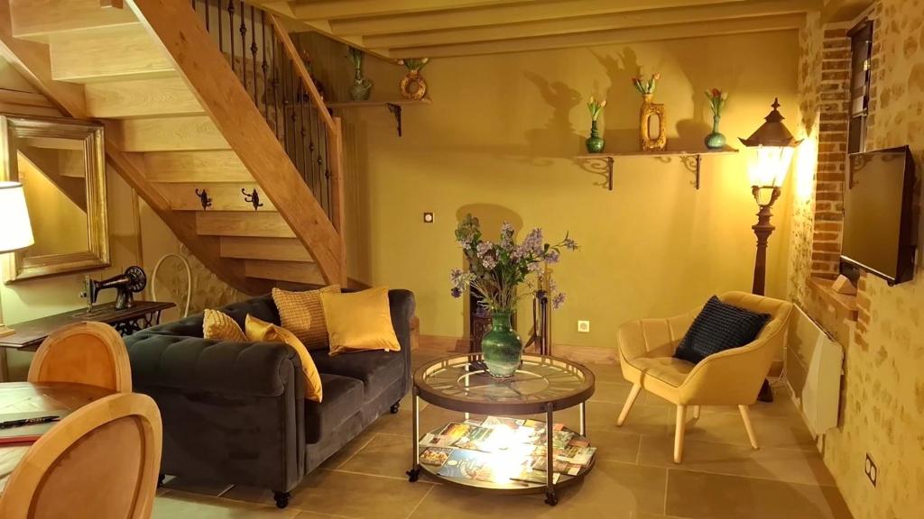 ein Wohnzimmer mit Sofa und Tisch in der Unterkunft Ancien moulin dans un cadre d exception in Ferrières-la-Verrerie