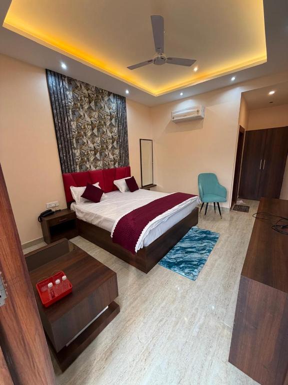 a bedroom with a large bed and a blue chair at Hr Palace in Varanasi