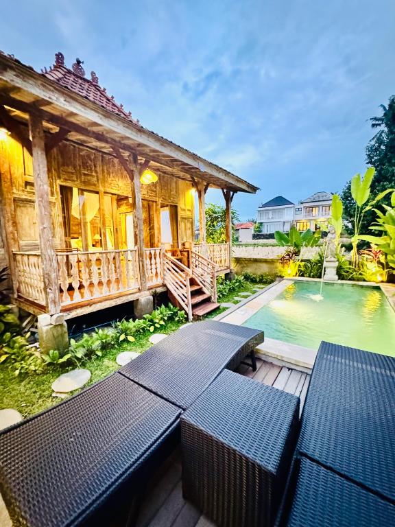 a house with a pool in front of a building at Sunshine dijoglo villa in Ubud