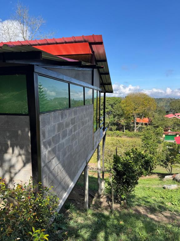 une maison avec un toit rouge sur une colline dans l'établissement Cabañas Ecoturísticas Villa Beatrice, à Estación El Salto