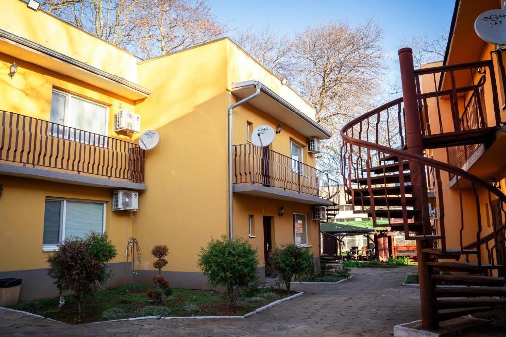 ein gelbes Gebäude mit einer Treppe daneben in der Unterkunft Хотел Олимпийски Надежди in Vratsa