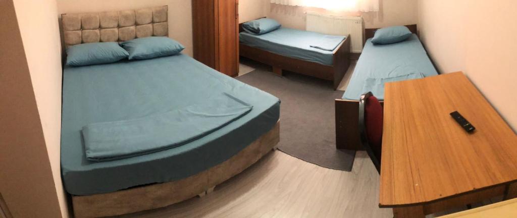 een kleine kamer met 2 bedden en een tafel bij Grand Aral Otel 