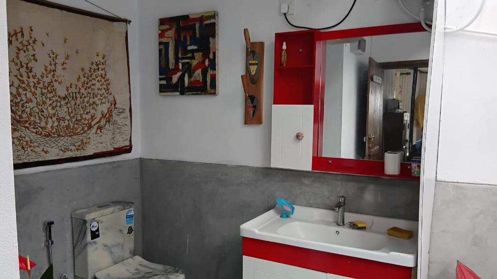 a bathroom with a sink and a red mirror at Aqua Vista Studio Appartment in Tangalle
