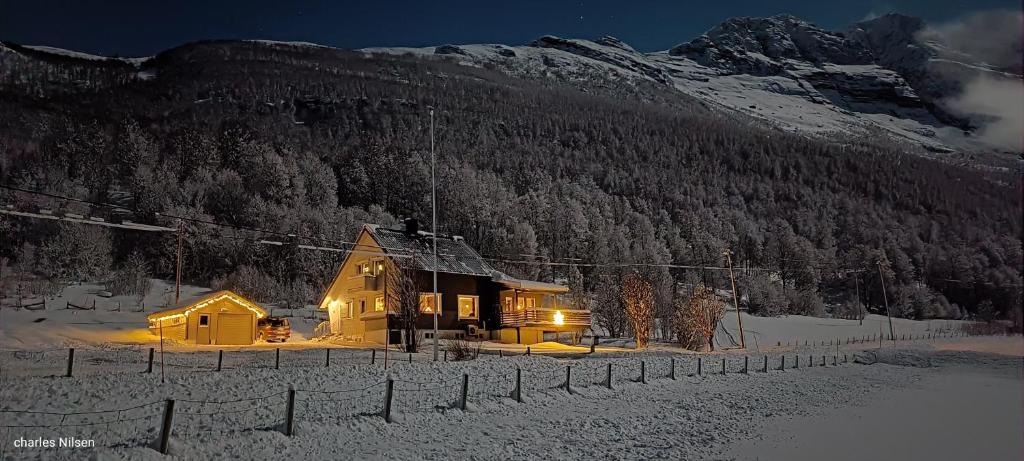 a house in the snow in front of a mountain at Charles Country House in Solstad