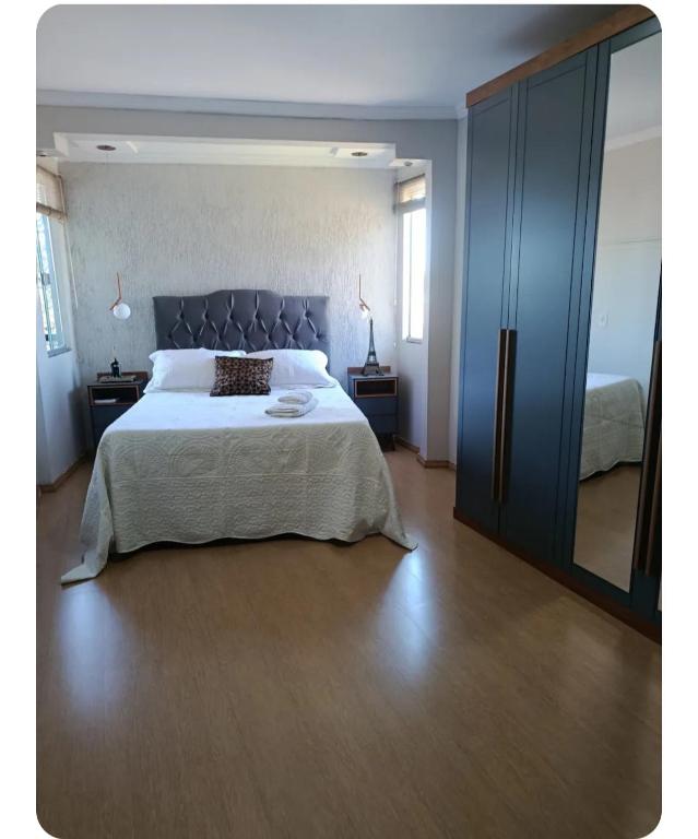 a bedroom with a large bed and a large mirror at Lindo Por do Sol, Quarto casal com Banheiro privativo, casa compartilhado in Pato Branco