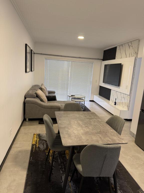 een woonkamer met een tafel en een bank bij The Grey Luxe Suite in Sandton