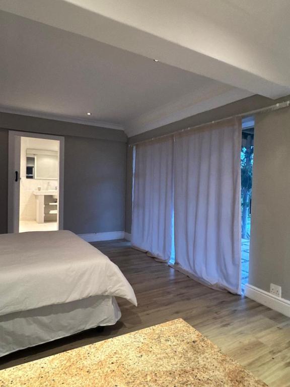 a bedroom with a bed and a large window at Bonza Bay Bliss in East London