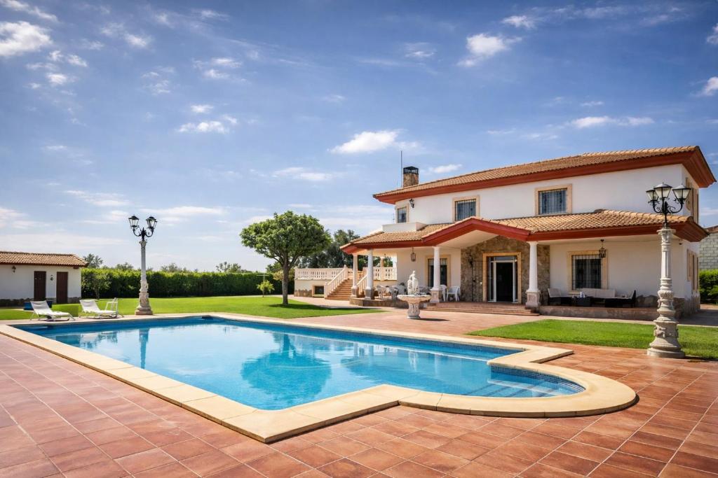 una piscina davanti a una casa di Casa Rural Los Gaspares a La Carlota