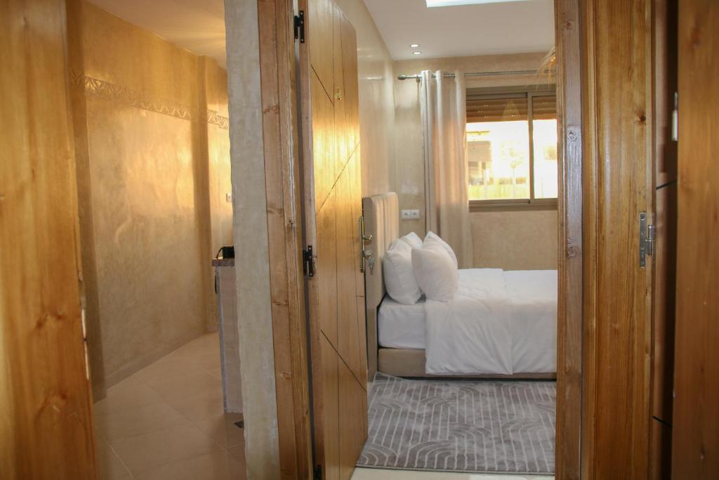 una piccola stanza con un letto e una finestra di Room a Imsouane