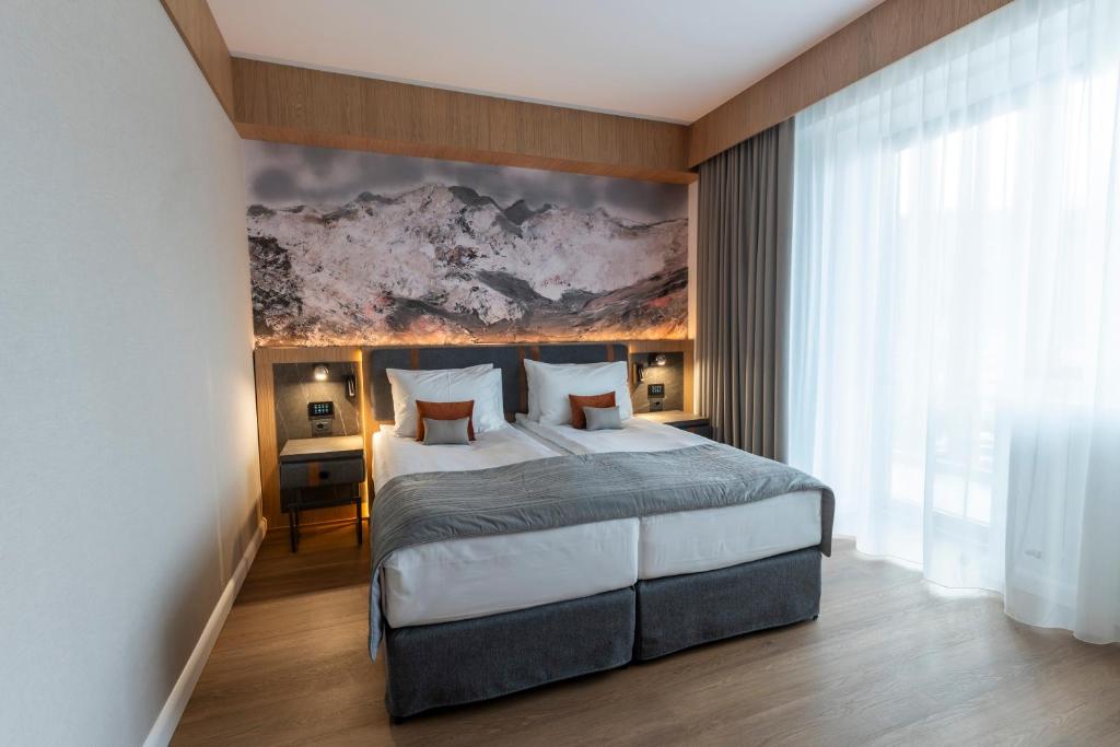 ein Schlafzimmer mit einem Bett und einem Gemälde an der Wand in der Unterkunft Azuga Ski and Bike Resort in Azuga