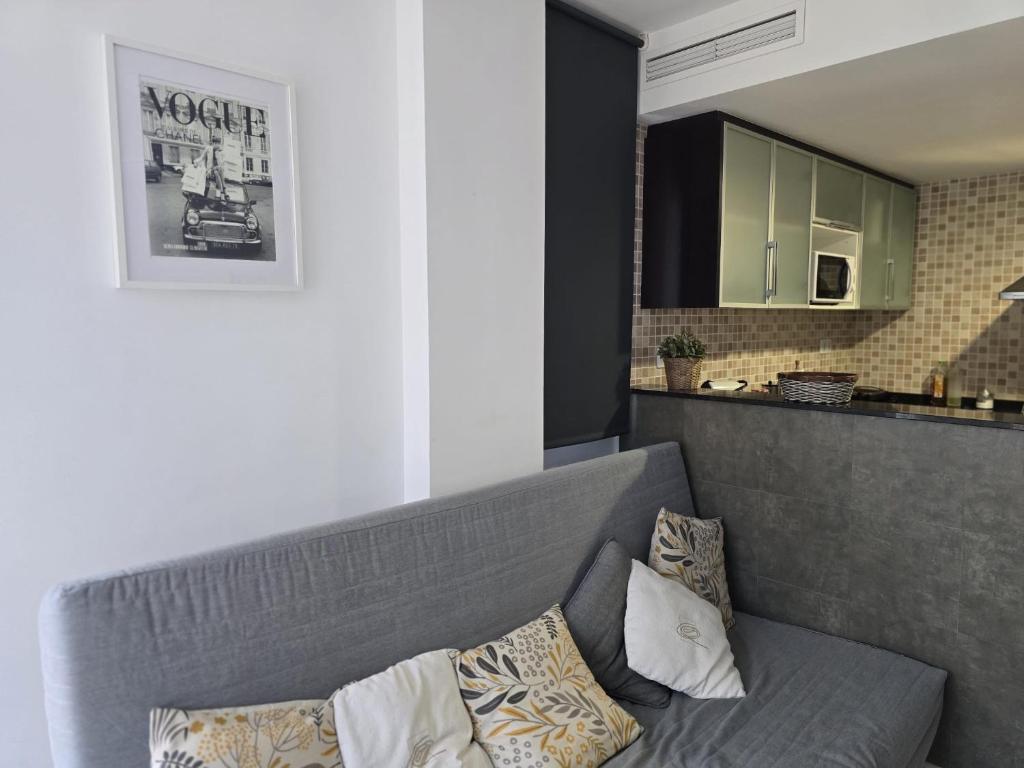 een woonkamer met een grijze bank met kussens bij Oliva Moon in Oliva