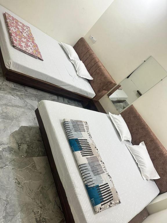 two beds in a room with a accordion on the bed at Maheshwari Homes in Ujjain